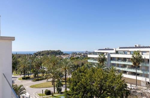 arial view of a building with palm trees and the ocean at Aqua Apartments Vento, Marbella in Marbella