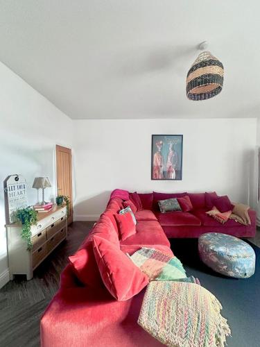 a living room with a red couch in a room at The Follonsby hot tub Retreat with own bar near city centre in Gateshead
