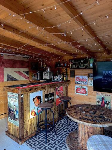 a bar with two tables and a tv in a room at The Follonsby hot tub Retreat with own bar near city centre in Gateshead