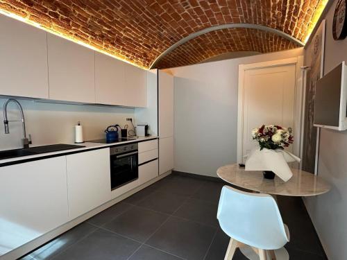 a kitchen with a table with a vase of flowers on it at S. Andrea in Vercelli