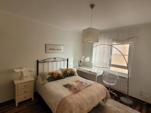 ein Schlafzimmer mit einem Bett mit Blumen darauf in der Unterkunft Grupo Gontad Apartamento Rompeolas in Laxe