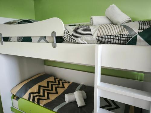 ビトラにあるM&M Apartmentのグリーンルームに二段ベッドが2つあり、ベッドが1台ある