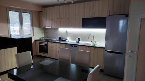 ビトラにあるM&M Apartmentのテーブルとステンレス製の冷蔵庫を備えたキッチン