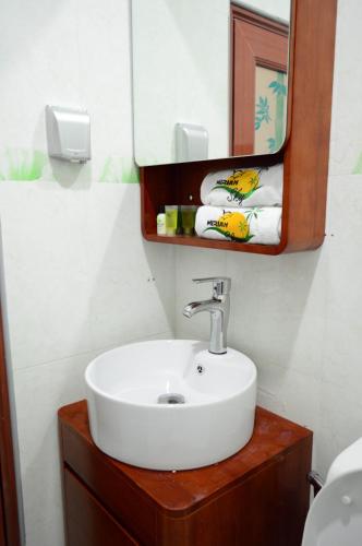 a bathroom with a sink and a mirror and towels at Mirian Sky in Gaafaru