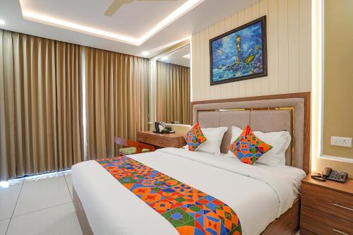 a hotel room with a large bed with colorful pillows at Oriva Freshco in Bengaluru