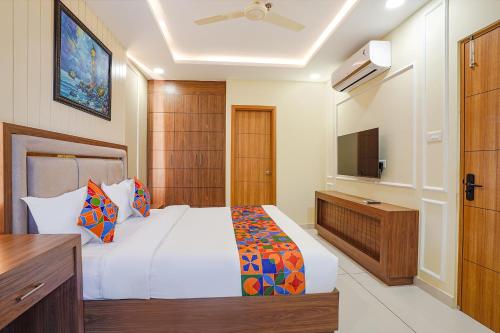 a bedroom with a white bed and a television at Oriva Freshco in Bengaluru