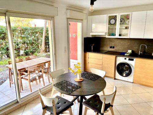une cuisine et une salle à manger avec une table et des chaises dans l'établissement Beachside Apartment with Pool & Garden in Juan les Pins, à Antibes