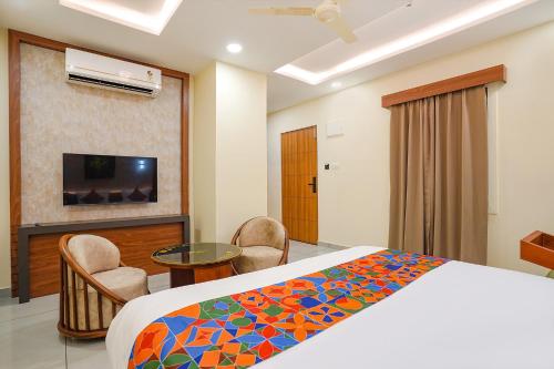 a bedroom with a bed and a tv and a table at Oriva Freshco in Bengaluru