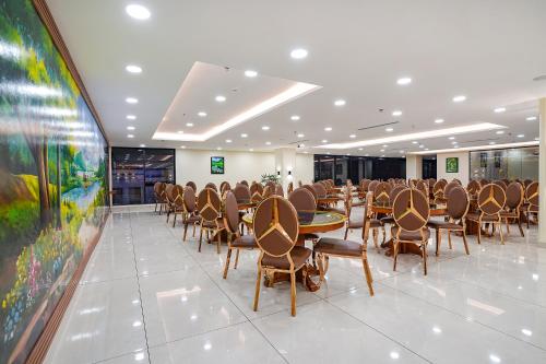 a conference room with tables and chairs and a painting at Oriva Freshco in Bengaluru