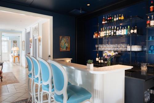 a bar with blue chairs and a counter at Hôtel de Toiras in Saint-Martin-de-Ré