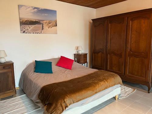 - une chambre avec un lit et 2 oreillers colorés dans l'établissement Maison Trinque Dit, à Audenge