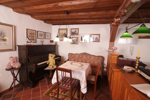 a living room with a table and a piano at Hotel und Gasthof Ritter St. Georg in Erlangen