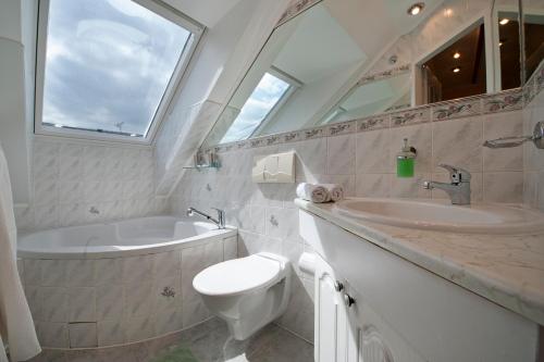 a bathroom with a sink and a toilet and a tub at A. V. Pension Praha in Prague