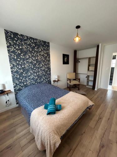 a bedroom with a bed with blue towels on it at Superbe pavillon 4 chambres - parking privé - Grande Terrasse au calme - limoges in Limoges