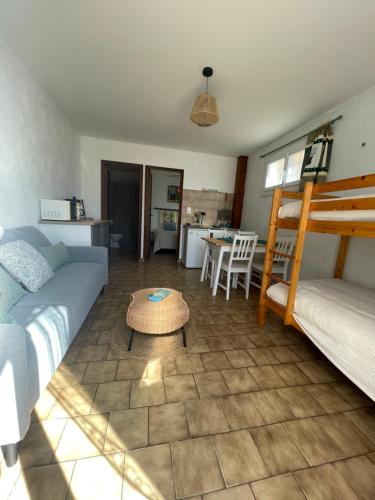 un salon avec un canapé, un lit et une table dans l'établissement Entre Mer et Vigne Caves, à Caves