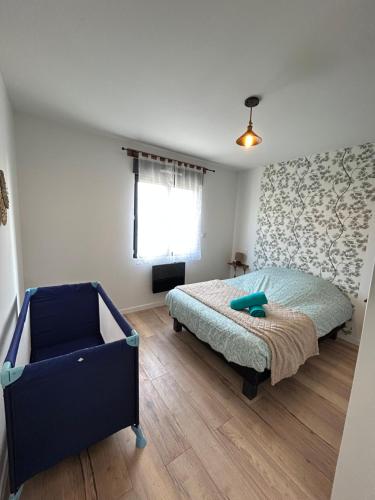 a bedroom with a bed and a blue chair at Superbe pavillon 4 chambres - parking privé - Grande Terrasse au calme - limoges in Limoges
