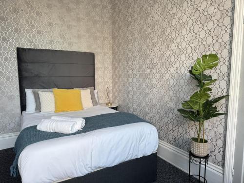 a bedroom with a bed and a plant in it at Marine Parade Hotel in Eastbourne