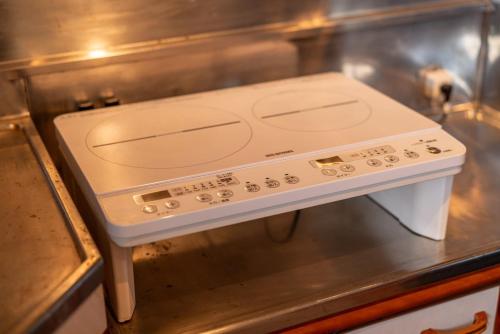 a stove top oven sitting on top of a kitchen counter at 珈琲好きのための和モダン貸切一軒家 in Iwaki