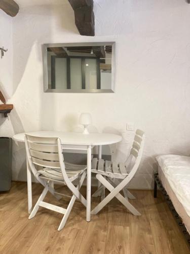 - une table et des chaises blanches dans une chambre avec un lit dans l'établissement Studio terrasse. A 50m de la plage Sablettes, à Menton