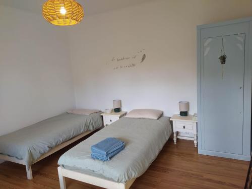 2 lits dans une chambre avec 2 tables et une lampe dans l'établissement Charming villa near Hossegor golf and lake, à Capbreton