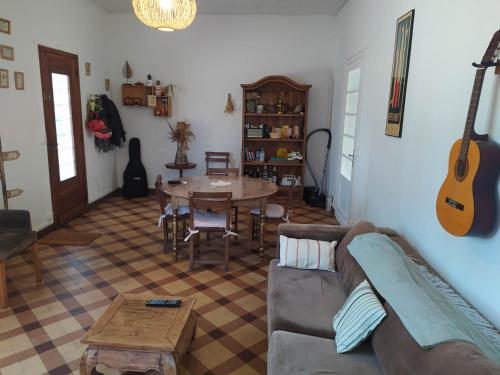 - un salon avec un canapé, une table et une guitare dans l'établissement Charming villa near Hossegor golf and lake, à Capbreton