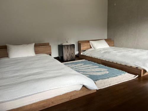 two beds sitting next to each other in a bedroom at 泊まれるカフェやわらかそう in Koka