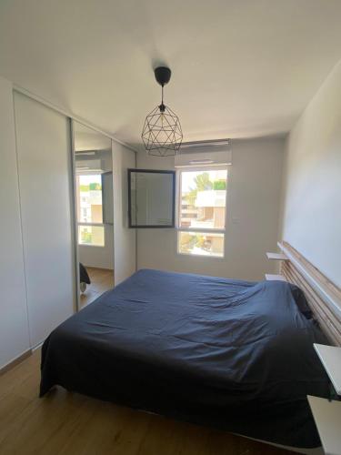 une chambre avec un grand lit avec une couverture bleue dans l'établissement Le Refuge du Plongeur - Appartement, à Saint-Mandrier-sur-Mer