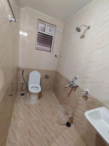 a bathroom with a toilet and a sink at Theo Suites Hotel Madhapur in Hyderabad
