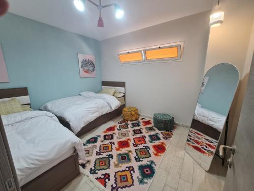 a bedroom with two beds and a rug on the floor at IL MONTE Galala -families only- المونت جلالة in Ain Sokhna