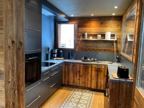 - une cuisine avec des murs bleus et des placards en bois dans l'établissement Chalet andreanna, à La Clusaz