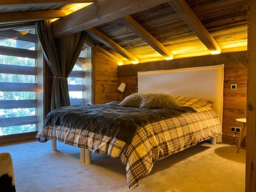 une chambre avec un lit dans une pièce aux murs en bois dans l'établissement Chalet andreanna, à La Clusaz