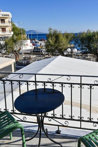 a table on a balcony with a view of a beach at Ikaria Studios in Agios Kirykos