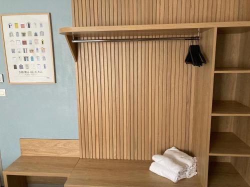 a room with a wooden book shelf with towels at Hôtel Le Rivage vue sur mer - Châtelaillon-plage in Châtelaillon-Plage