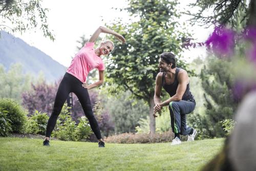 two people playing with a frisbee in a field at Ferien & Wellnesshotel Windschar in Brunico