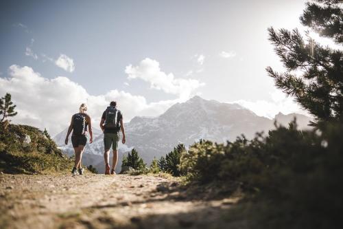 a man and woman walking down a mountain road at Ferien & Wellnesshotel Windschar in Brunico