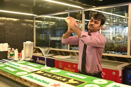 a man adjusting his tie in front of a table at Kumar Resort By Turtle, Lonavala in Lonavala