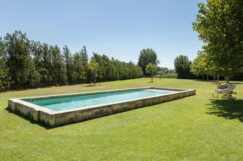 une piscine au milieu d'une cour dans l'établissement Mas spacieux Les Agasses calme - Isle sur sorgue, à LʼIsle-sur-la-Sorgue