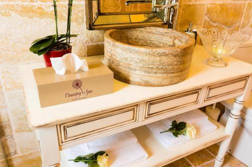 a white console table with a bowl on top at Country SPA Village in Ciofliceni