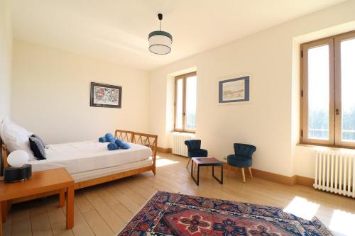 une chambre avec un lit, une table et des chaises dans l'établissement Mas spacieux Les Agasses calme - Isle sur sorgue, à LʼIsle-sur-la-Sorgue