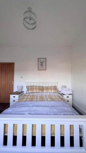 a bedroom with a large bed with a blanket at The Follonsby hot tub Retreat with own bar near city centre in Gateshead