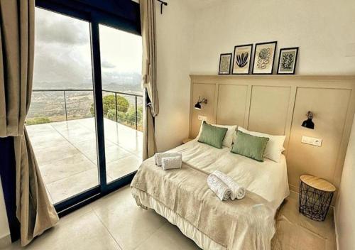 Un dormitorio con una cama y una ventana grande. en Villa 90 by Villamya, en El Gastor