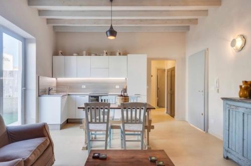 a kitchen and living room with a table and chairs at Wp Relais apartments in Diso