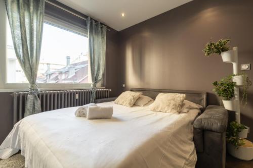 une chambre avec un grand lit blanc avec une fenêtre dans l'établissement Ecrin, à Annecy