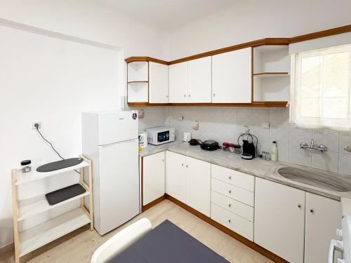 a kitchen with white cabinets and a white refrigerator at Filio's home in Zárakes
