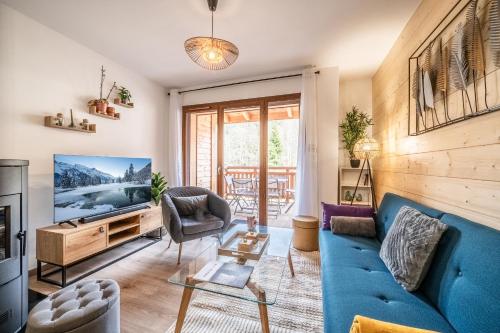 a living room with a blue couch and a tv at Apartment Thredbo, Les Carroz d'Arâches - by EMERALD STAY in Arâches-la-Frasse