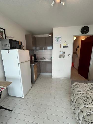 une cuisine avec un réfrigérateur blanc dans une pièce dans l'établissement GROOMI Le Cap D'or- Beachfront with air conditioning!, à Palavas-les-Flots