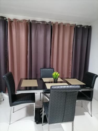 a dining room with a table and chairs and curtains at Roxas Blvd Stunning Studio Condo Near US Embassy in Manila