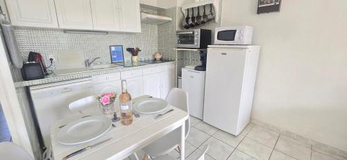 La cuisine est équipée de 2 lavabos et d'un réfrigérateur. dans l'établissement Appartement 2 chambres, jardin & parking à Valras, à Valras-Plage