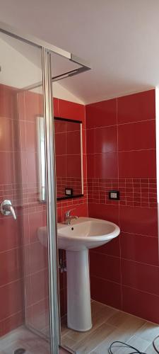 a red bathroom with a sink and a shower at Villa Lancellotti in Agropoli