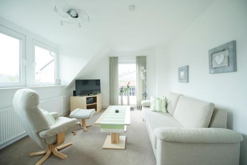 a living room with a couch and a table at Appartementhaus Bahlo inklusive THERMEplus in Bad Bevensen